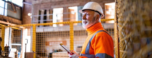 Mitarbeiter mit Helm in einer Lagehalle