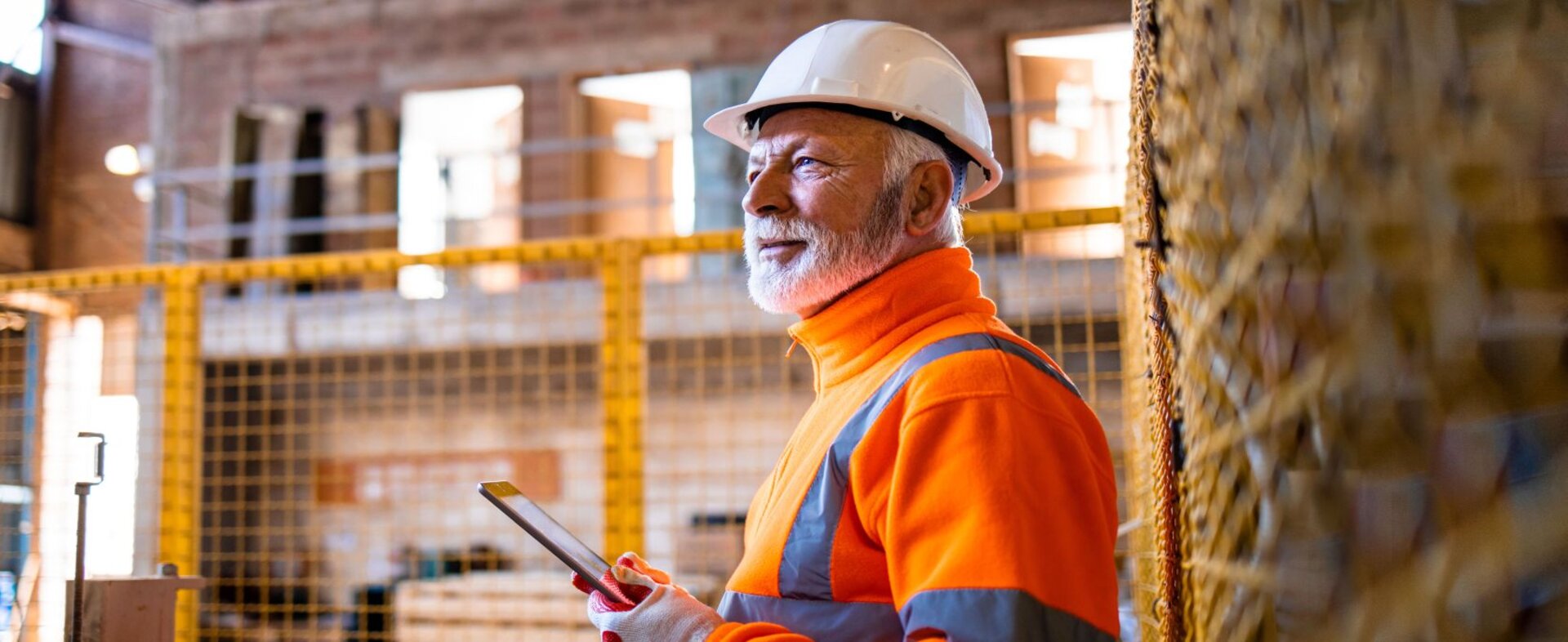 Mitarbeiter mit Helm in einer Lagehalle