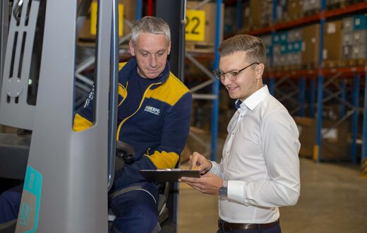 Mitarbeiter besprechen sich in einer Lagerhalle
