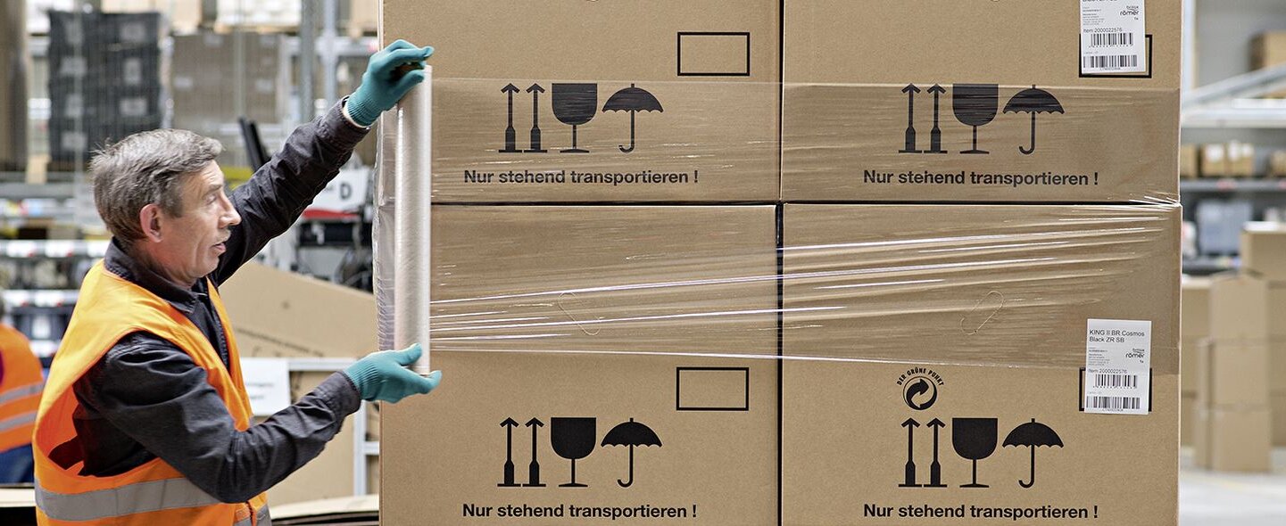 Lagermitarbeiter packt Pakete ein